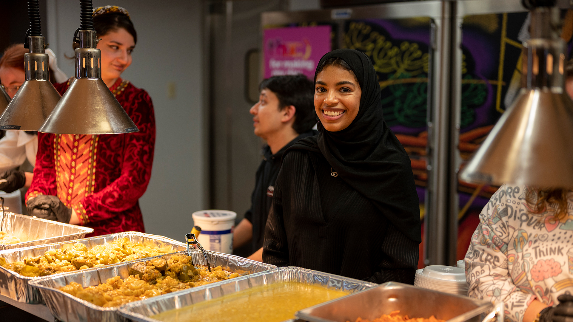 A middle eastern student preparing to serve food from a tray