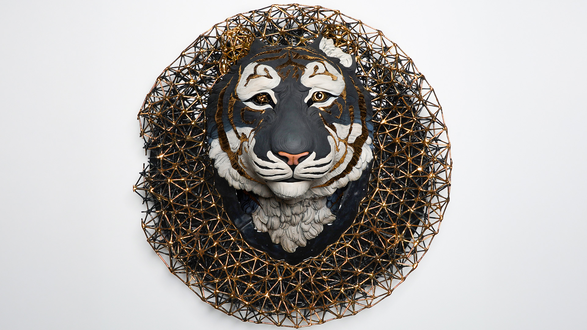 Artwork featuring a tiger head hanging on a wall encircled by golden latticework