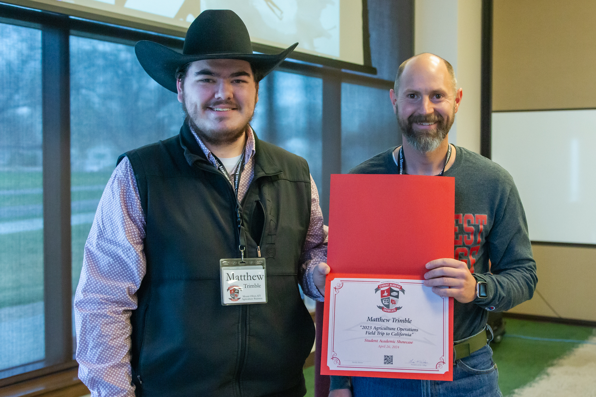 An agriculture student and his professor holding certificate